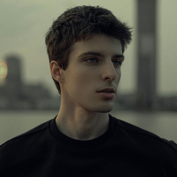 Silhouette of a man stretching against a soft light background.